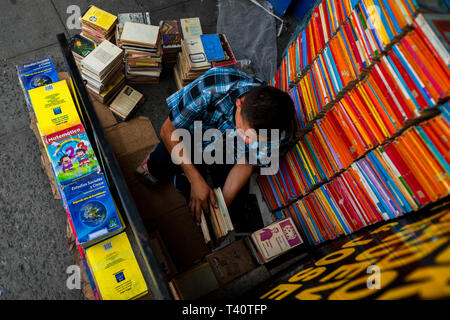 Eine salvadorianische Buchhändler Stapel Bücher in Stapeln auf der Straße in einen gebrauchten Buchhandlung in San Salvador, El Salvador. Stockfoto