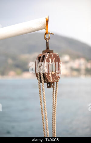 Riemenscheibe und Seil auf einem Schiff, Fähre in Montenegro, Bucht von Kotor. Segelboot Ausrüstung. Wichtige Nautische Details. Sicherheit an Bord. Stockfoto