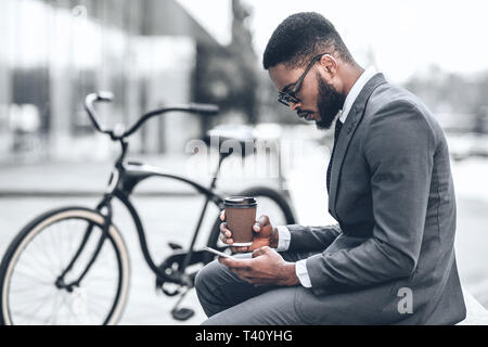 Gut aussehender Geschäftsmann im Internet surfen während der Kaffeepause Stockfoto