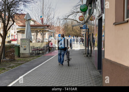 Slavonski Brod, Kroatien, März 05, 2019: Lokale Mann drücken Fahrrad an Petra Krešimira IV Street Stockfoto