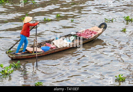 Ein fleisch Hersteller am frühen Morgen schwimmenden Markt im Mekong Delta, Vietnam Stockfoto