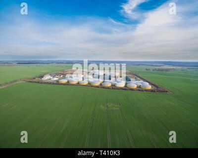 Luftaufnahme von einer großen Biogasanlage zwischen grünen landwirtschaftlichen Feldern in Deutschland - grüne saubere Energie Stockfoto