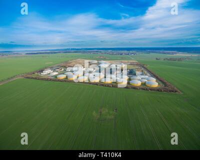 Luftaufnahme von einer großen Biogasanlage zwischen grünen landwirtschaftlichen Feldern in Deutschland - grüne saubere Energie Stockfoto