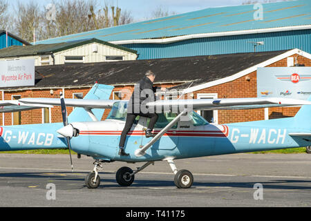 HIGH WYCOMBE, ENGLAND - MÄRZ 2019: Person prüfen Sie den Kraftstofftank vor Flug mit einer Cessna Aerobat Licht trainer Flugzeuge in Wycombe Air Park. Stockfoto