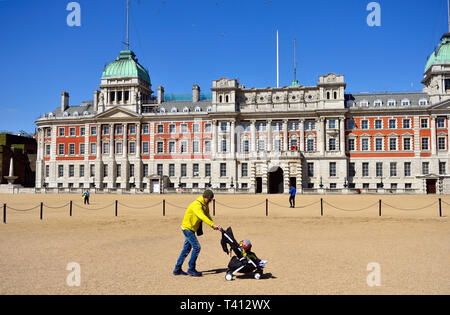 London, England, UK. Man treibt ein Kind im Kinderwagen über Horse Guards Parade Stockfoto