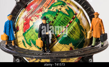 Reisende auf der ganzen Welt: miniatur Figuren auf einem Globus Stockfoto