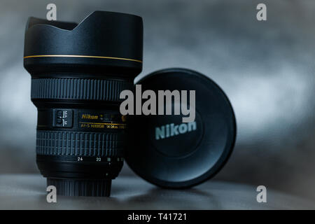 Ein Nikon 14-24mm Weitwinkel-Zoomobjektiv gegen eine Moody grauer Hintergrund sitzen. Stockfoto