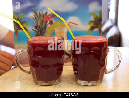 Person, die neben zwei Pints Granatapfelsaft, Iran Stockfoto