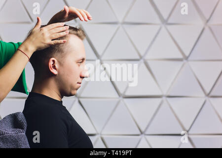 Weibliche Friseur die Haare trocknen Ihre männlichen Kunden in ihrem Friseursalon. Stockfoto
