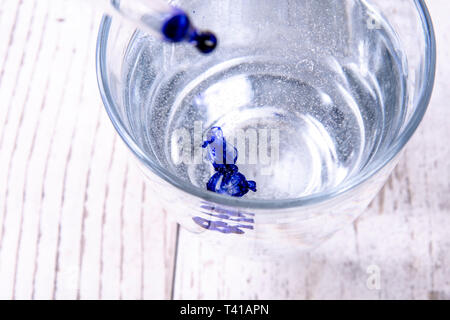 Blaue Tinte in Wasser Glas und Pipette Stockfoto