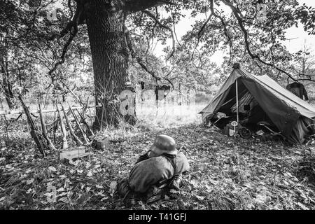 Weltkrieg Deutsche Wehrmacht Infanterie Soldat Armee Waffe Munition. Helm, Gewehre, Zelt, in Forest Camp. WWII WW2 Deutscher Munition. Foto in Schwarz Stockfoto