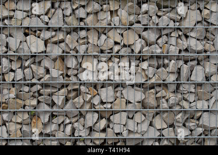 Schutz Zaun oder Mauer aus gabionen mit grauen Steinen Stockfoto