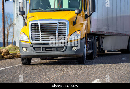 Vorderansicht des Gelben Tag cab professionelle zuverlässige Güterverkehr Big Rig amerikanischen Motorhaube Semi Truck für den lokalen Transport Transport von Waren in Stockfoto