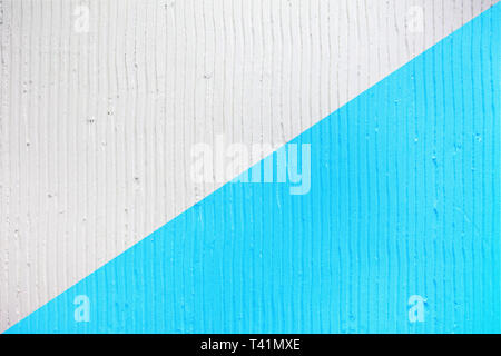 Detailansicht der Wand mit einem dekorativen Putz vertikale Linien und Streifen. Trendy zweifarbig Hintergrund Textur. Strukturierte weiße und blaue Betonwand. Stockfoto