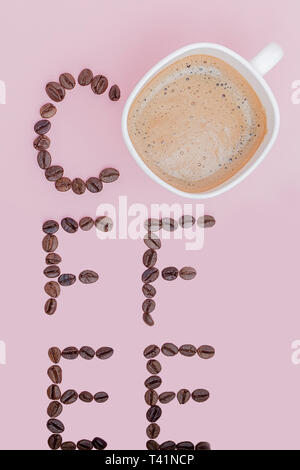 Text aus Kaffeebohnen: Kaffee. Textur der Kaffeebohnen auf einem rosa Hintergrund. Stinkende, satten Braun arabischen Kaffee Bohnen. Kopieren Sie Platz. Stockfoto