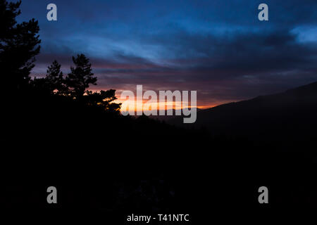 Schönen Sonnenuntergang zwischen Bergen und Wäldern Stockfoto