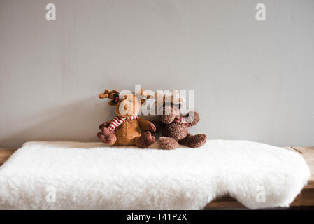 Die beiden Elche Kinder Stofftiere sitzt auf einem weissen Teppich Stockfoto