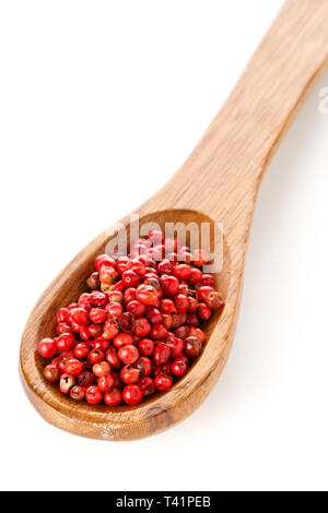 Pink oder Rosa brasilianischen roter Pfeffer (Schinus terebinthifolius) Löffel aus Holz mit weißem Hintergrund Stockfoto