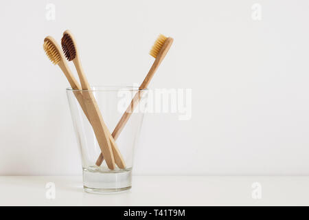 Menge der natürlichen Zahnbürsten im Glas auf dem Tisch im Badezimmer. Stockfoto