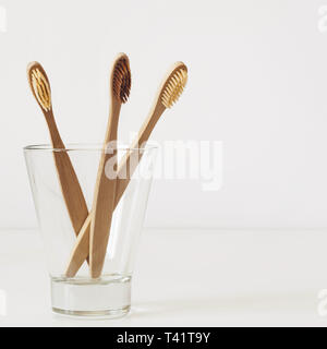 Natürliche Bambus Zahnbürsten in Glas auf weißen Bad. Stockfoto