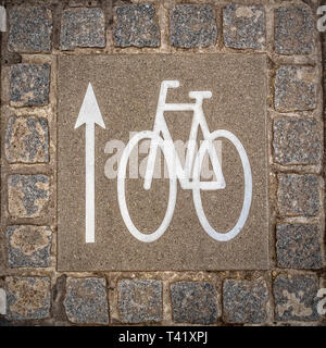 Ein Fahrrad lane Zeichen auf dem Boden, der die Fahrtrichtung. Stockfoto