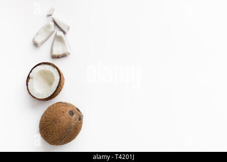 Ganze und gehackte Kokosnüsse auf Weiß Stockfoto