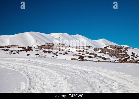 Die Straße nach Nida Hochebene mit Schnee bedeckt. Im Hintergrund die höchsten Gipfel des Psiloritis. Rethymno, Kreta, Griechenland. Stockfoto