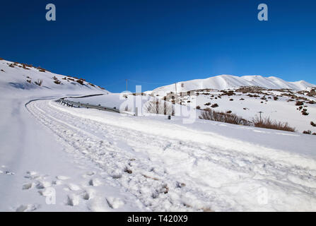 Die Straße nach Nida Hochebene mit Schnee bedeckt. Im Hintergrund die höchsten Gipfel des Psiloritis. Rethymno, Kreta, Griechenland. Stockfoto