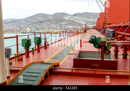 Noworossijsk, Russland - 20. August 2017: Blick auf das Meer und den Strand der Stadt vom Hafen Quay. Industrielle Hafen mit Kran- und Cargo Infrastruktur. Stockfoto