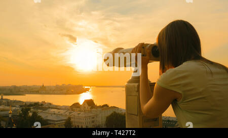 Junge Frau durch touristische Teleskop suchen, historischen Teil der Stadt zu erkunden Stockfoto