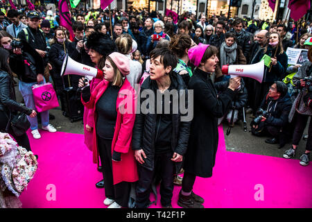 London, Londo, UK. 12 Apr, 2019. Aktivisten sind das Singen während der Veranstaltung. Das Aussterben Rebellion Mode Action Group ging zum Oxford Circus zum Stillstand durch die Inszenierung eine kreative und symbolische catwalk Titel Mode: Zirkus der Selbstbeteiligung. Ziel ist es, den Alarm über die Rolle der Mode Konsum spielt in der Klima- und Ökologische Not zu erhöhen. Die Modeindustrie ist ein Viertel der weltweit CO2-Budget 2050 in Bekleidung Produktion zu verbrauchen. Credit: Brais G. Rouco/SOPA Images/ZUMA Draht/Alamy leben Nachrichten Stockfoto