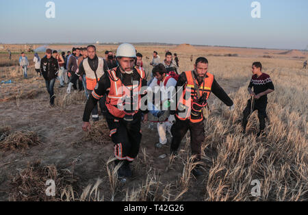 Palästinensische Sanitäter werden gesehen, die eine verletzte Demonstrant während der Demonstration in der Nähe der Grenze zu Israel, östlich von Khan Yunis im südlichen Gazastreifen. Ein palästinensischer Jugendlicher erschossen wurde durch die israelische Armee während der erneuten Auseinandersetzungen auf der Grenze zum Gazastreifen, das Gesundheitsministerium in den palästinensischen Enklave, sagte ein Ministeriumssprecher sagte Abu Shaloof Maysara, 15, ist heiß im Magen wurde durch die (Israelische) Besatzung östlich von Jabalia, die sich zu einer Demonstration Site im nördlichen Gaza-Streifen. Stockfoto