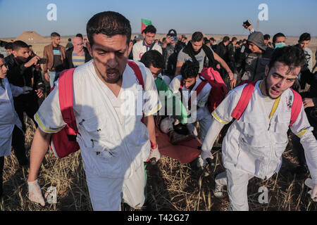 Palästinensische Sanitäter werden gesehen, die eine verletzte Demonstrant während der Demonstration in der Nähe der Grenze zu Israel, östlich von Khan Yunis im südlichen Gazastreifen. Ein palästinensischer Jugendlicher erschossen wurde durch die israelische Armee während der erneuten Auseinandersetzungen auf der Grenze zum Gazastreifen, das Gesundheitsministerium in den palästinensischen Enklave, sagte ein Ministeriumssprecher sagte Abu Shaloof Maysara, 15, ist heiß im Magen wurde durch die (Israelische) Besatzung östlich von Jabalia, die sich zu einer Demonstration Site im nördlichen Gaza-Streifen. Stockfoto