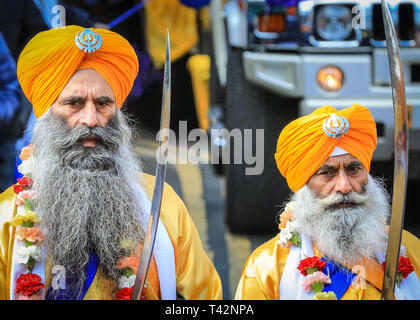 Gravesend, Kent, Großbritannien, 13. April 2019. Die fünf Sikh-Männer, die den Panj Pyare repräsentieren (fünf geliebte), an der Vorderseite der Prozession, gefolgt vom Festwagen mit dem Schrein. Sikh-Teilnehmer tragen den traditionellen Kirpan, einen Dolch oder ein Schwert und Turban. Tausende von Zuschauern und religiösen Besuchern säumen die Straßen von Gravesend in Kent, um die jährliche Vaisakhi-Prozession zu beobachten und daran teilzunehmen. Vaisakhi wird von der Sikh-Gemeinschaft auf der ganzen Welt gefeiert. Stockfoto