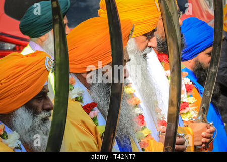 Gravesend, Kent, Großbritannien, 13. April 2019. Die fünf Sikh-Männer, die den Panj Pyare repräsentieren (fünf geliebte), an der Vorderseite der Prozession, gefolgt vom Festwagen mit dem Schrein. Sikh-Teilnehmer tragen den traditionellen Kirpan, einen Dolch oder ein Schwert und Turban. Tausende von Zuschauern und religiösen Besuchern säumen die Straßen von Gravesend in Kent, um die jährliche Vaisakhi-Prozession zu beobachten und daran teilzunehmen. Vaisakhi wird von der Sikh-Gemeinschaft auf der ganzen Welt gefeiert. Stockfoto
