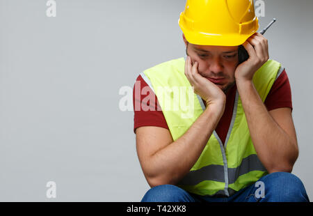 Foto von umgekippt builder Männer in gelben Helm mit walkie-talkie auf leeren grauen Hintergrund Stockfoto