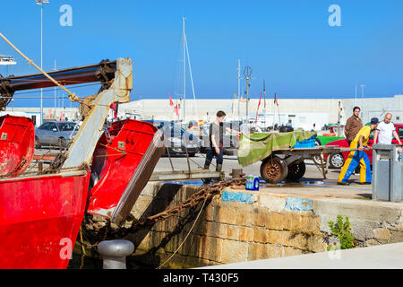 Blanes, Spanien - 31. Mai, 2018: Fischer entladen Fang von Fischen, Austern, Tintenfisch, Meer Köstlichkeiten. Fischerboote und Yachten vor Anker an der Pier im Hafen Blan Stockfoto