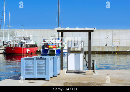 Weiß Kraftstoff Dispenser am Boat Tankstelle an der Strandpromenade, Hafen Blanes. Öl Industrie für Transport zu Wasser. Fischerboote und Yachten in der Marina vor Anker. Stockfoto