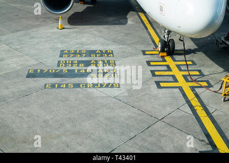 MANCHESTER, Großbritannien - 9 April 2019: Text auf dem Asphalt einer Start- und Landebahn am Flughafen Manchester, Großbritannien Stockfoto