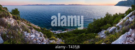 Abend Sommer Küste Ansicht mit rosa Sonnenuntergang und Insel am Horizont (Ston, Peljesac, Kroatien) Stockfoto