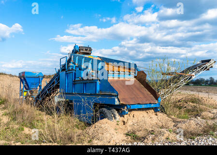 Alte, mobile Screen für Kies und Sand in die Farbe Blau stehend auf dem Feld, im Hintergrund blauer Himmel mit Wolken. Stockfoto