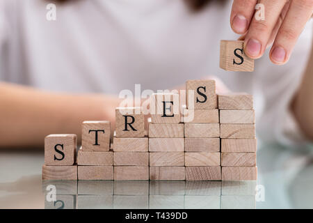 Nahaufnahme der Hand letzte Alphabet der Person des Wortes Stress auf hölzernen Block Stockfoto