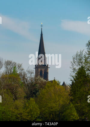 Der Turm der Pfarrkirche St. Matthias hinter grüne Bäume im Frühjahr in Neuwied, Deutschland Stockfoto