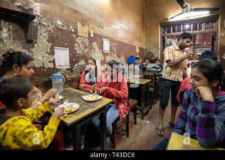 Horizontale Ansicht Lokale Leute in einem ramshackled Restaurant in Kalkutta aka Kalkutta, Indien zu essen. Stockfoto