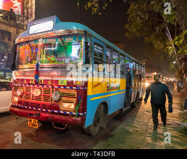 Horizontale Sicht auf einen öffentlichen Bus hinunter die Straße in Kalkutta aka Kalkutta, Indien fahren. Stockfoto