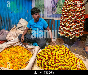 Horizontale Ansicht eines Mannes verkauf Ringelblume Girlanden an Mullik Ghat Blumenmarkt in Kalkutta aka Kalkutta, Indien. Stockfoto