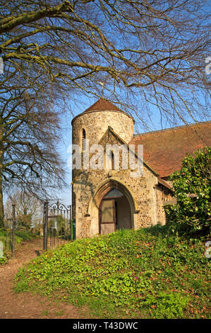 Ein Blick auf den runden Turm und Vorhalle der Pfarrkirche Allerheiligen an Freethorpe, Norfolk, England, Vereinigtes Königreich, Europa. Stockfoto