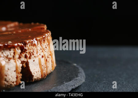 Pie mit Karamell schließen bis auf dunklem Hintergrund. Kuchen mit Banane und Karamell. Stockfoto