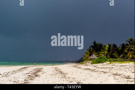 Tropischer Strand mit silhouetes der unkenntlich Menschen in der Ferne Stockfoto