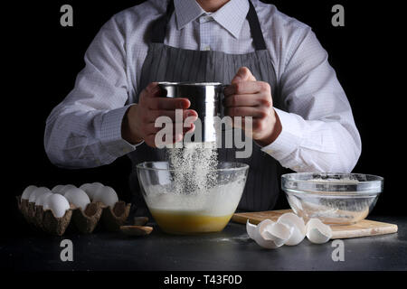 Sichten Mehl auf dunklem Hintergrund. Rezept Kuchen oder Kuchen machen Konzept. Stockfoto